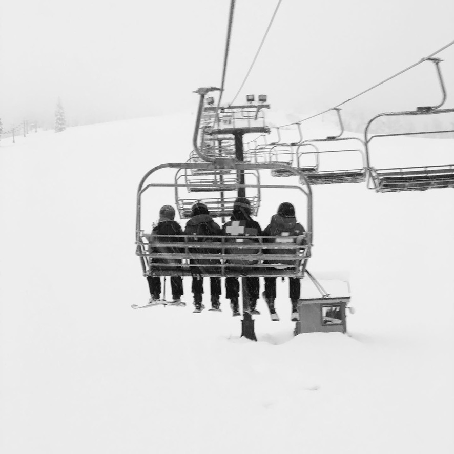 ski patrollers riding the chair lift in bad weather