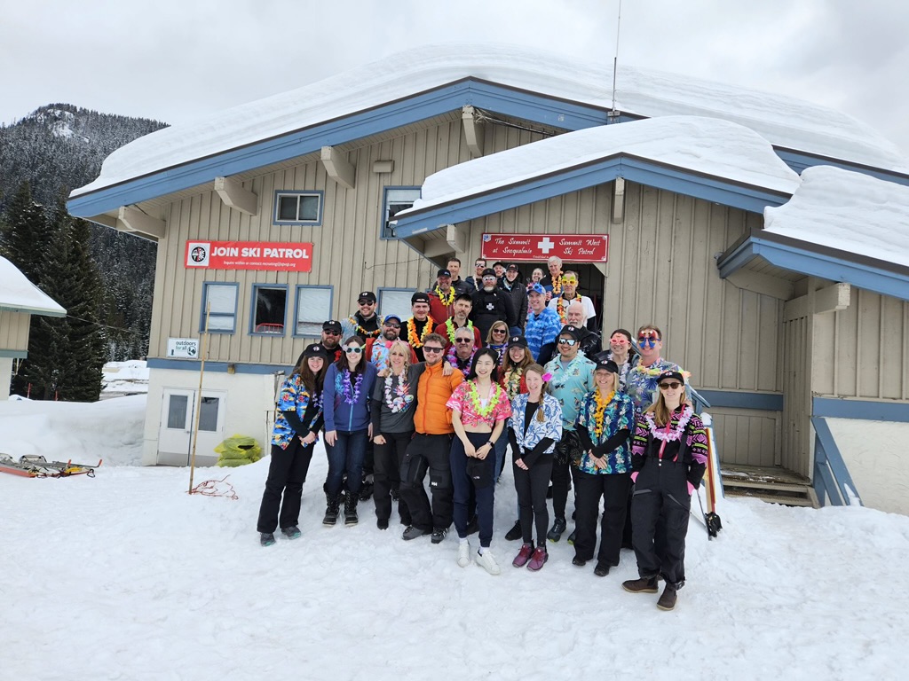 a picture of all members of the ski patrol standing in front of the patrol building